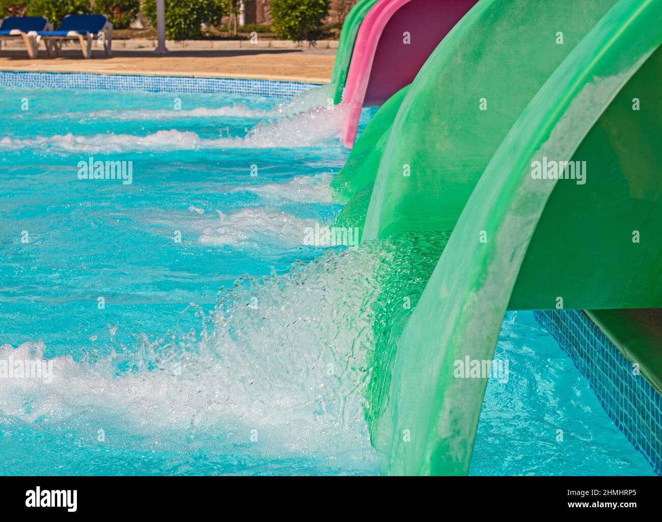 Water entering swimming pool from end of aqua park slide creating splash motion abstract effect Stock Photo
