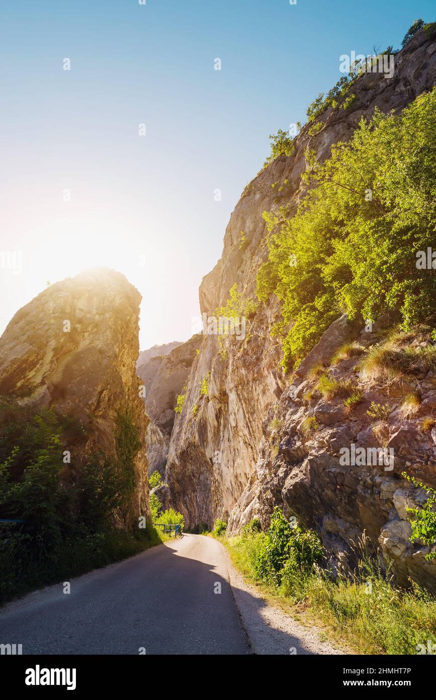 Narrow road pass between rocky cliffs vertical Stock Photo