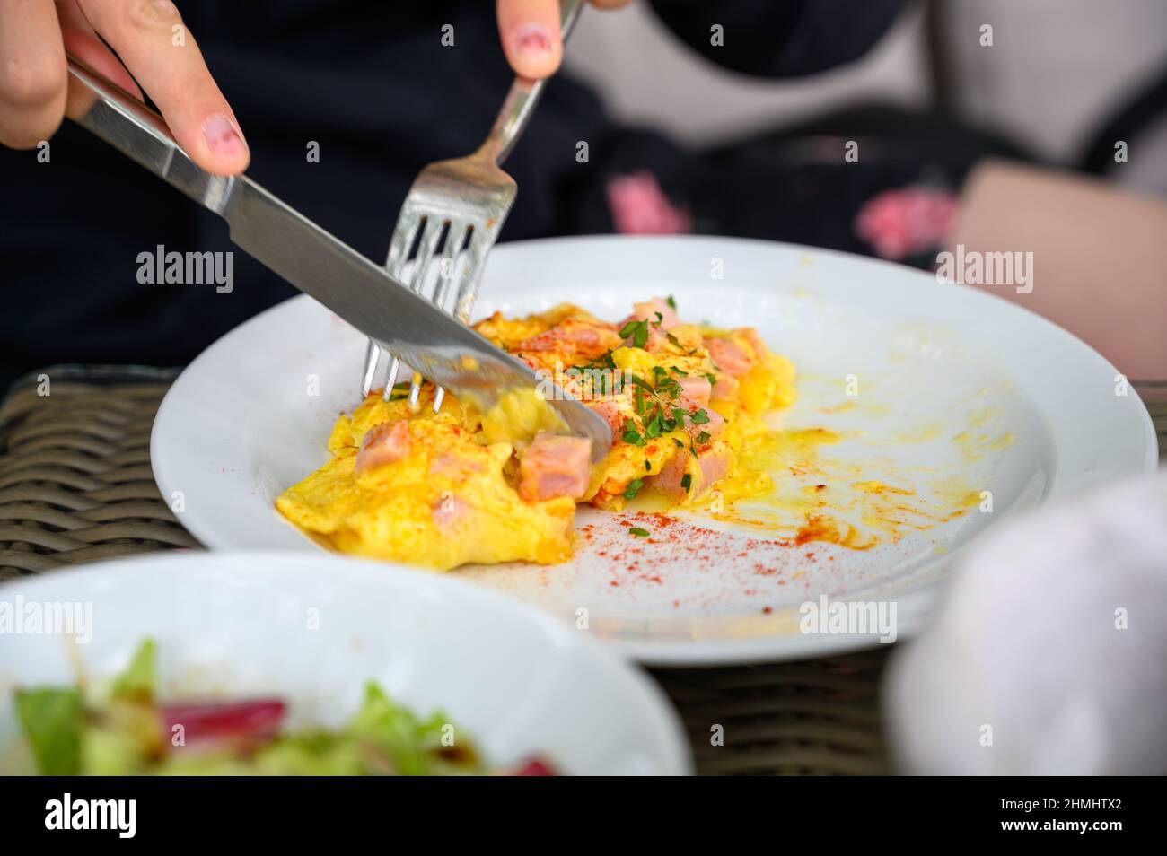 A knife and fork being used to cut up an omelette Stock Photo Alamy