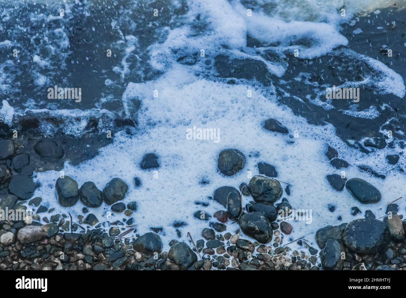 White foam water near the stone coast of lake foamy Stock Photo Alamy