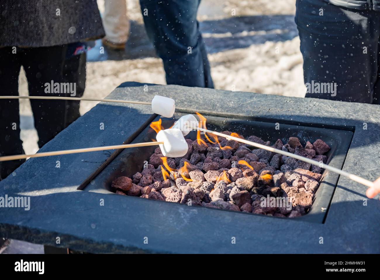 A marshmallow on a stick being roasted over a camping fire Stock Photo