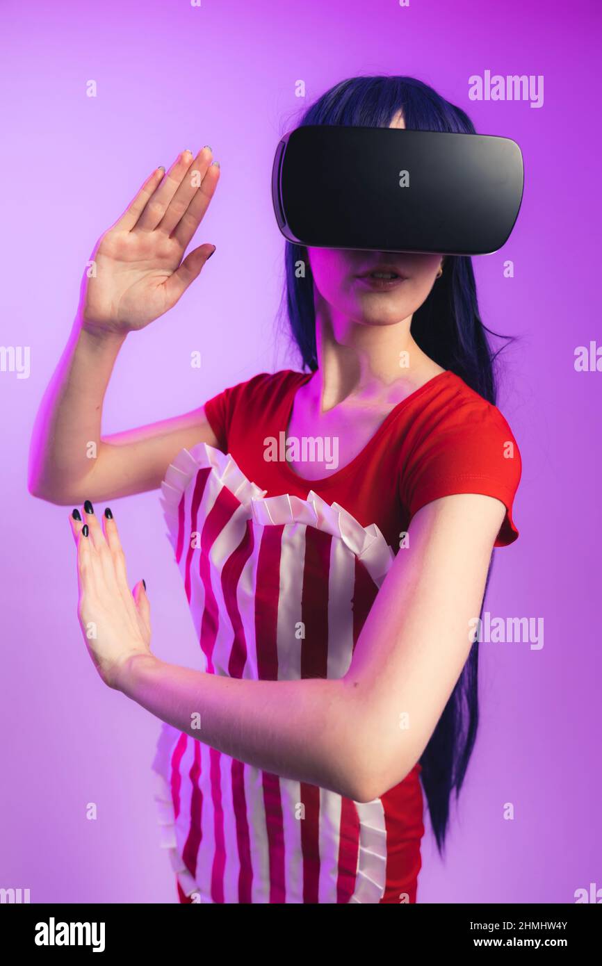 happy young caucasian woman using a virtual reality headset medium studio shot magenta background high quality photo 2HMHW4Y