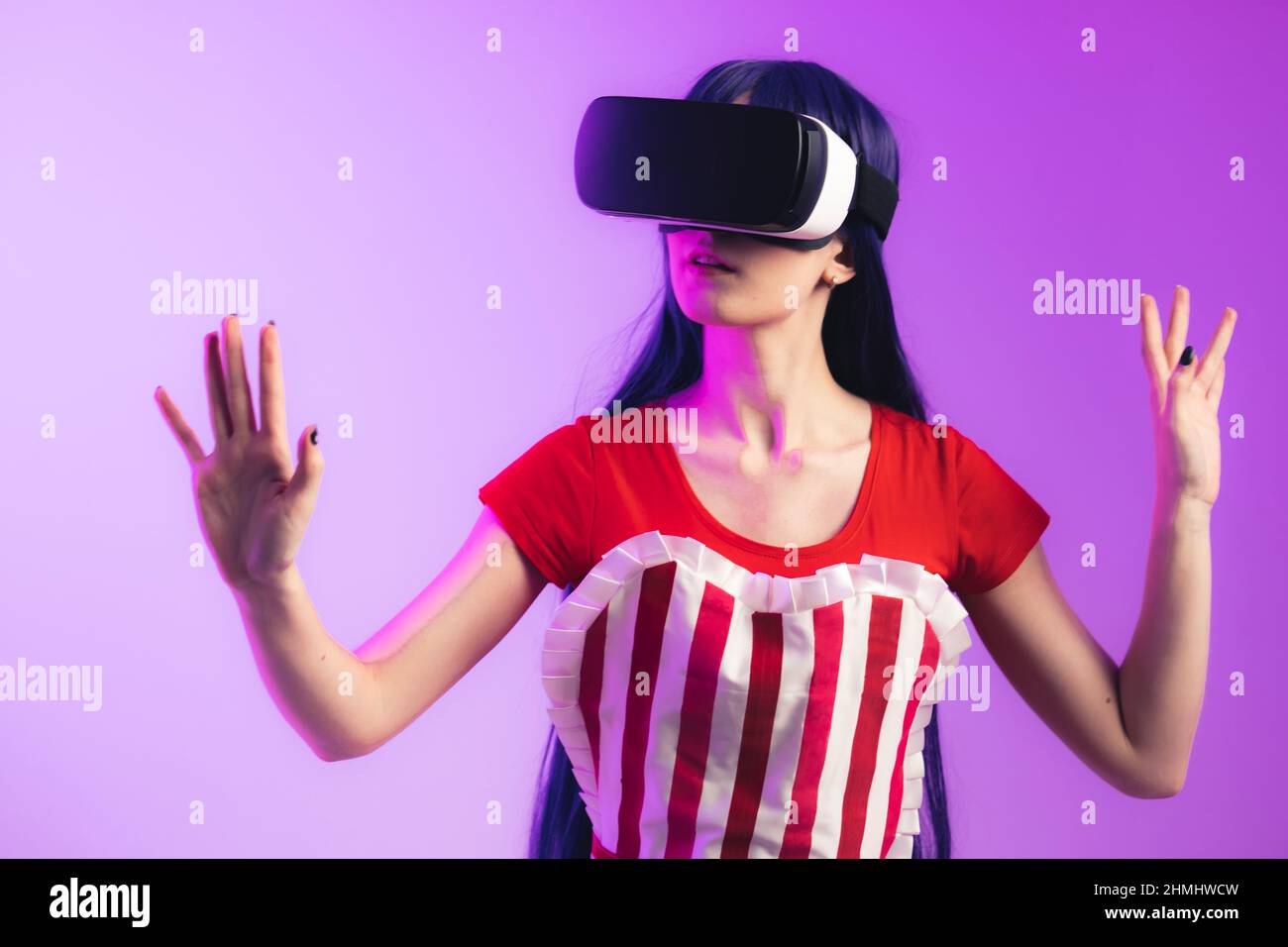 European model with long hair and vr glasses is rising her hands medium studio shot magenta background. High quality photo Stock Photo