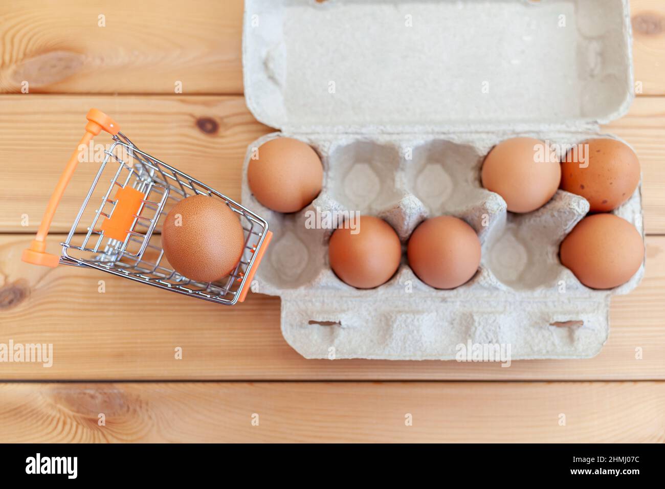 A few chicken eggs in the shopping basket next to cardboard bag, a
