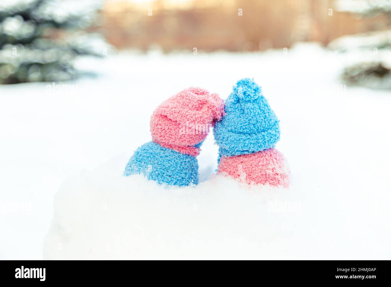 Cute homemade snowmen with scarves and hats, back view. Winter's Tale. Greeting card with copy space. Winter background. Stock Photo