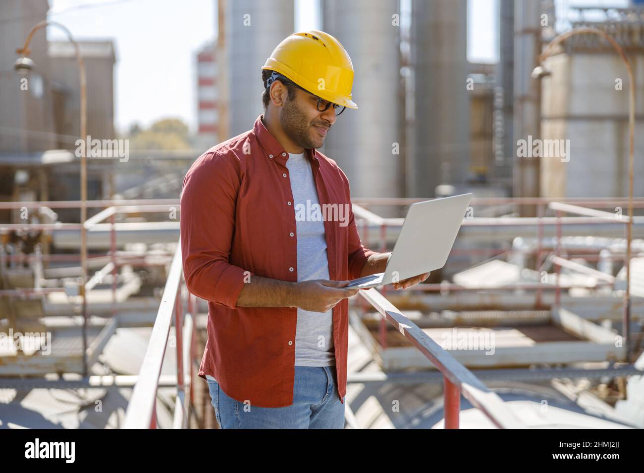 Young industrial engineer with using laptop at plant Stock Photo