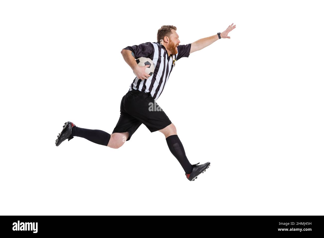 Dynamic portrait of soccer or football referee running with football ball isolated on white