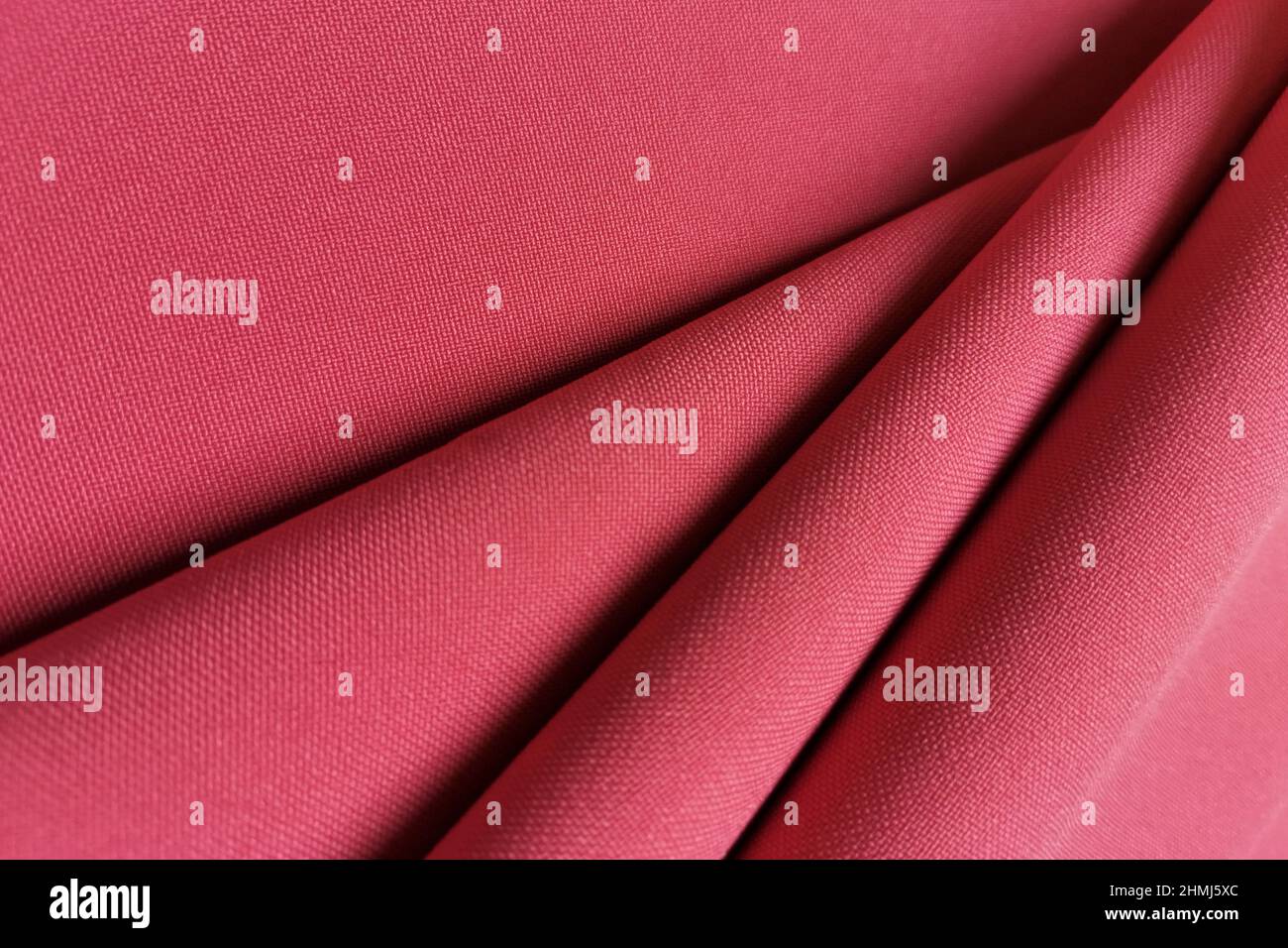 Pink crumpled or wavy fabric texture background. Abstract linen cloth soft waves. Gabardine wool fabric. Merino yarn. Smooth elegant luxury cloth Stock Photo