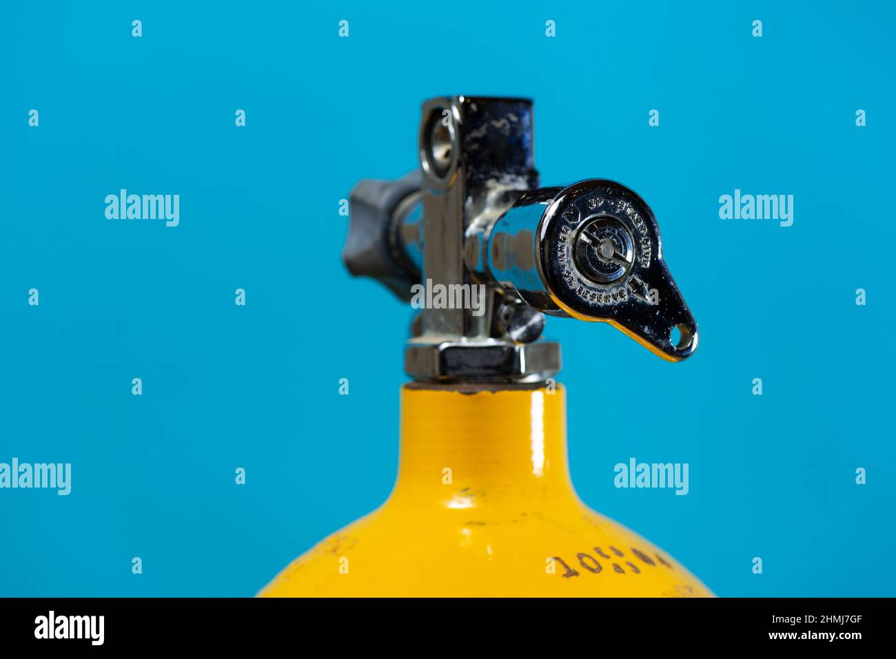 J valve in the open position on a vintage yellow steel scuba tank Stock