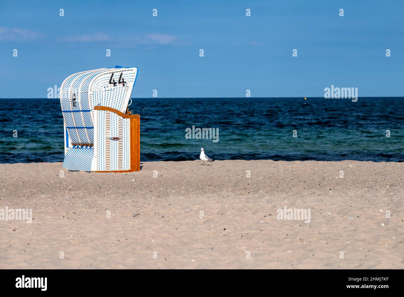 An empty beach chair on the Baltic Sea (Hohwacht) and the seagull seems to wait for her 'breadwiner'. Stock Photo