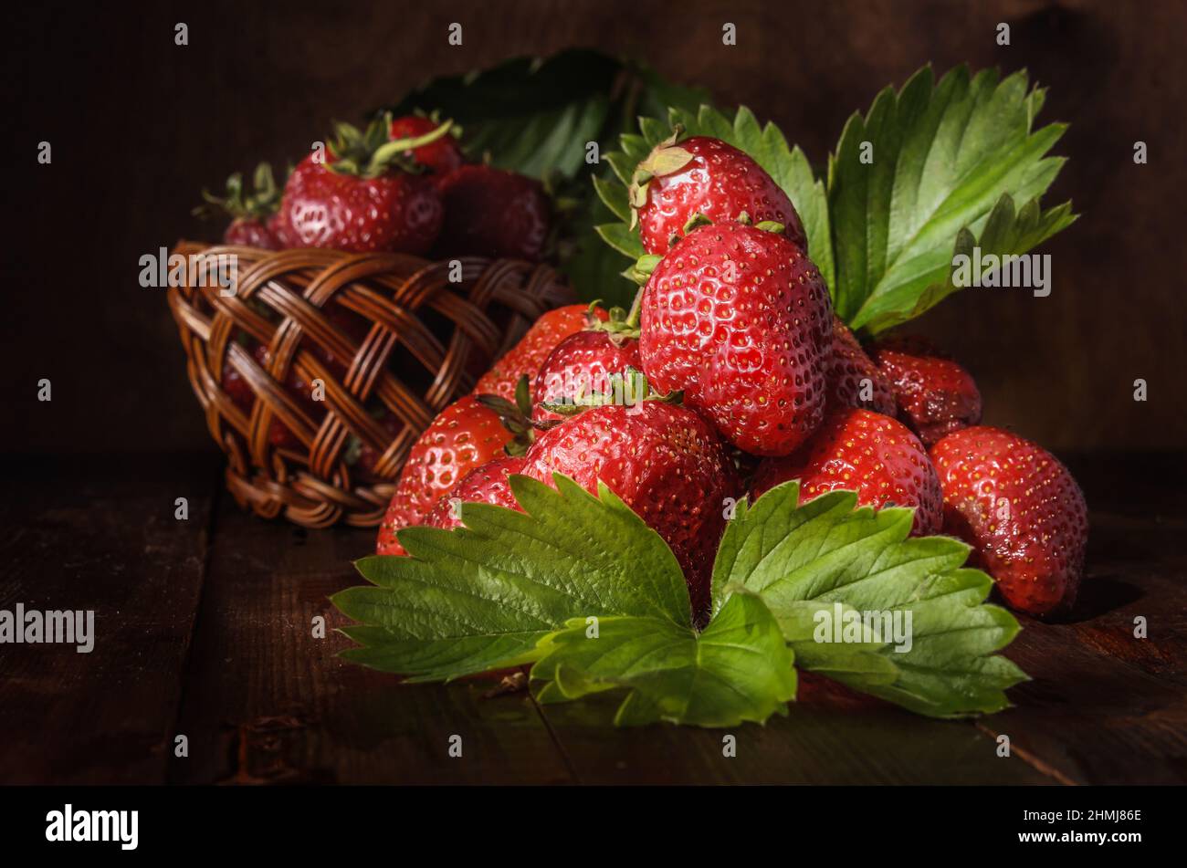 berries of ripe strawberries on a dark wooden background in a rustic style Stock Photo
