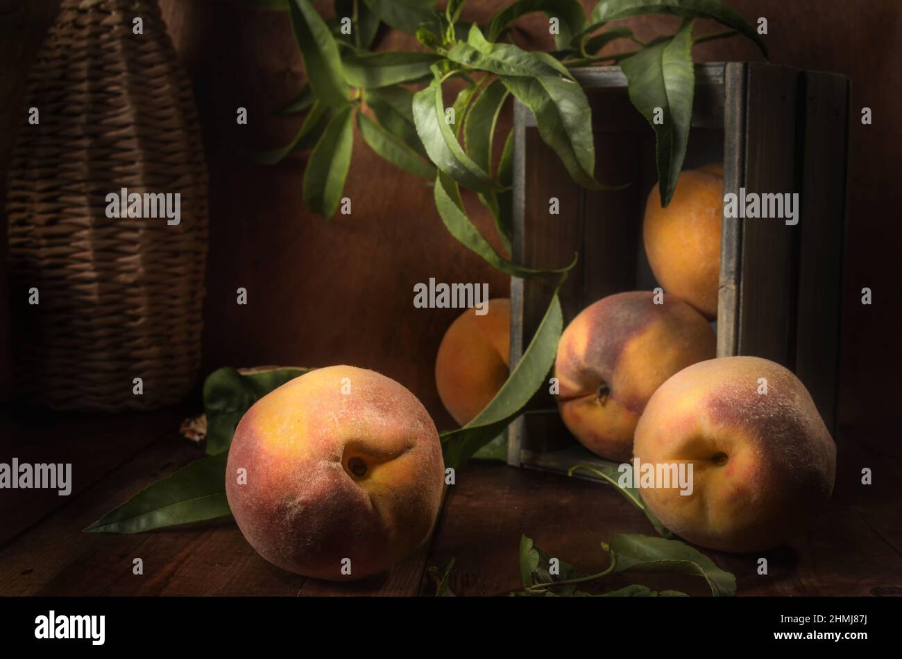 ripe peaches in a wooden box on a dark background in a rustic style Stock Photo