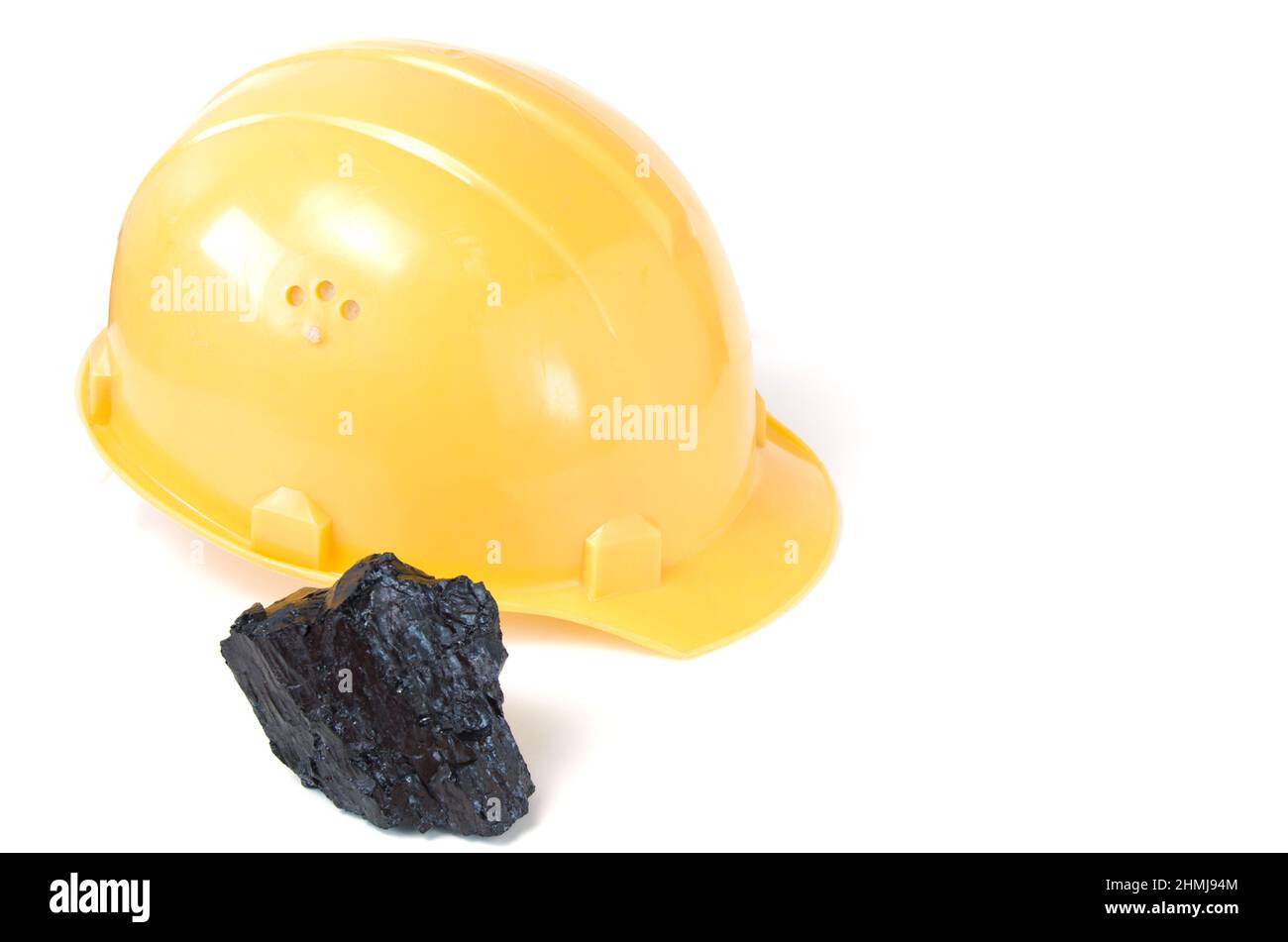 Mining helmet and piece of coal on white background.Mining production. Stock Photo