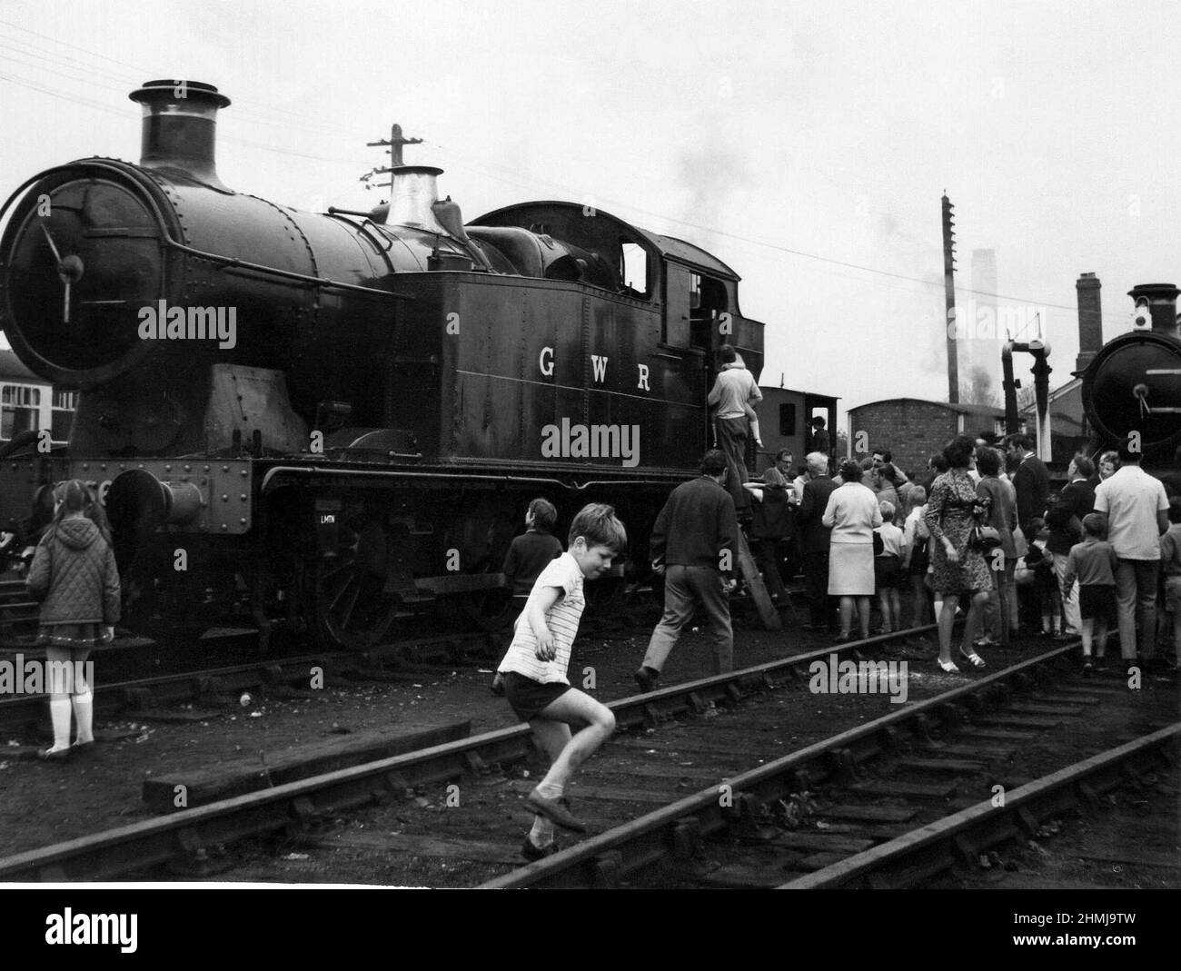 A small boy steps over railway tracks at the Great Western Society open day at the Didcot Railway Centre in Oxfordshire, England on June 10, 1972. Stock Photo