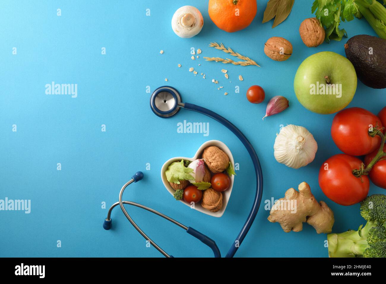 Natural dietary medicine with healthy food and stethoscope on blue background. Top view. Horizontal composition. Stock Photo