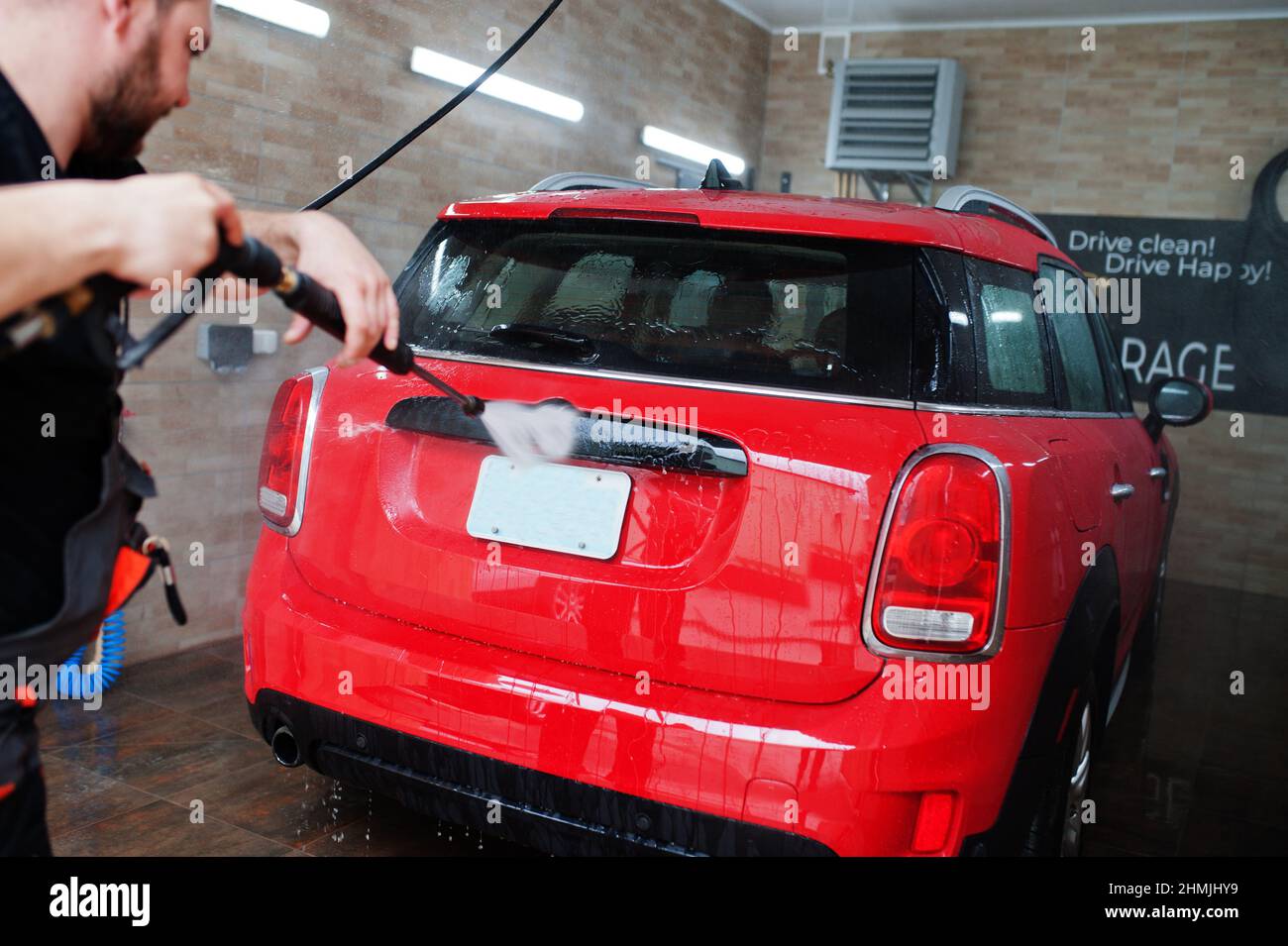 Man worker washing red car in detailing garage Stock Photo Alamy