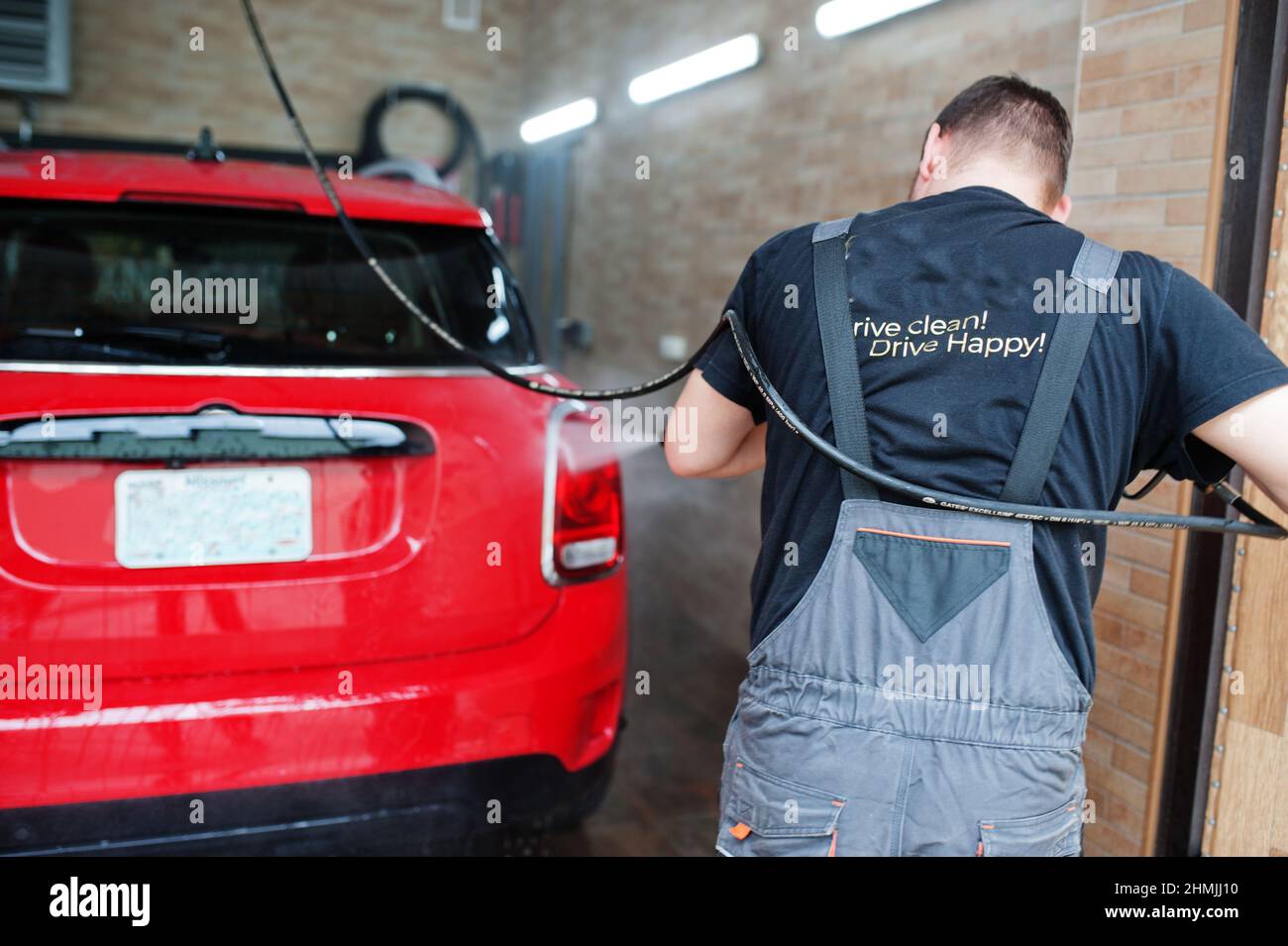 Man worker washing red car in detailing garage Stock Photo Alamy