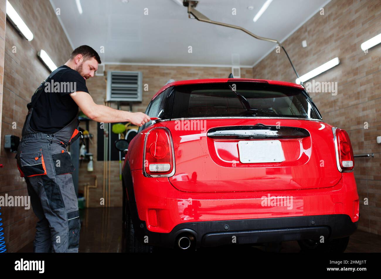 Man worker washing red car in detailing garage Stock Photo Alamy