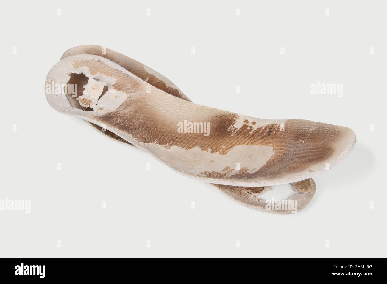 Two old, shabby orthopedic insoles isolated on white background. Dirty