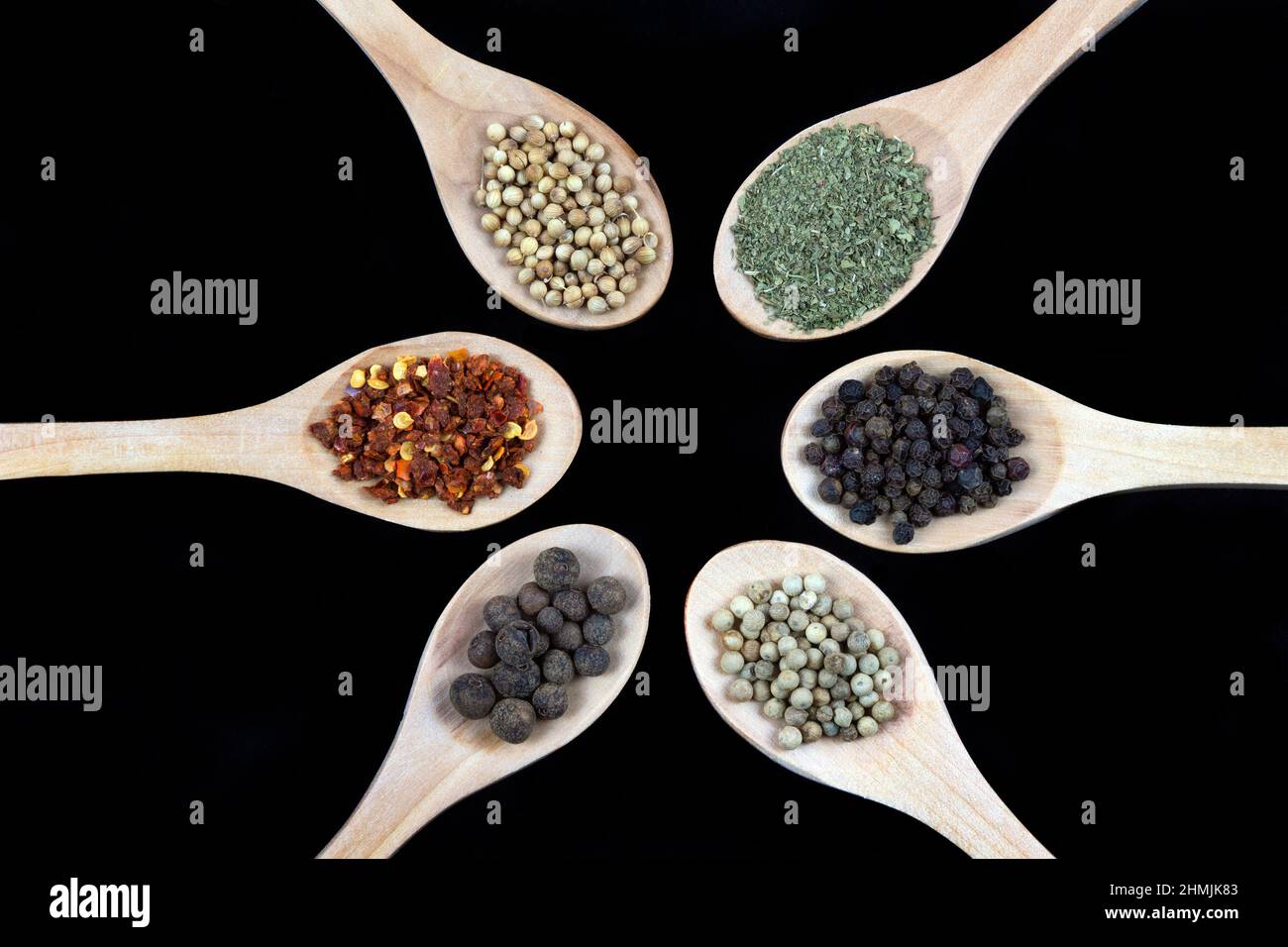 Spices in wooden spoon isolated on black background Stock Photo