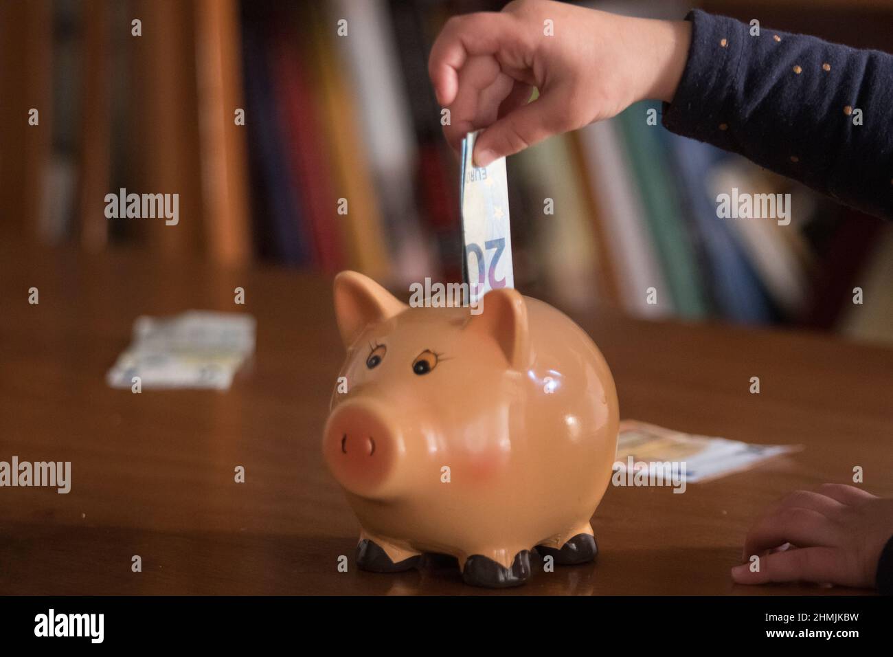 Putting ticket into piggy bank at home. Stock Photo