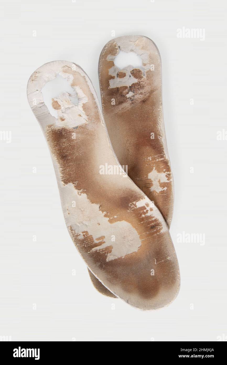 Two old, shabby orthopedic insoles isolated on white background. Dirty