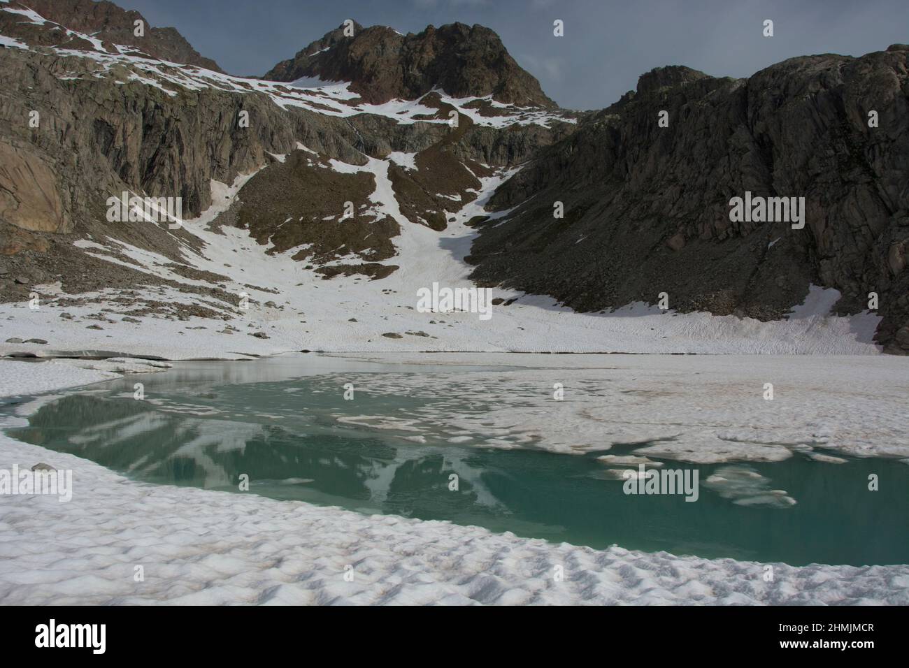 Der mit Schnee und Eis gefüllte Gruebensee im Berner Oberland Stock Photo