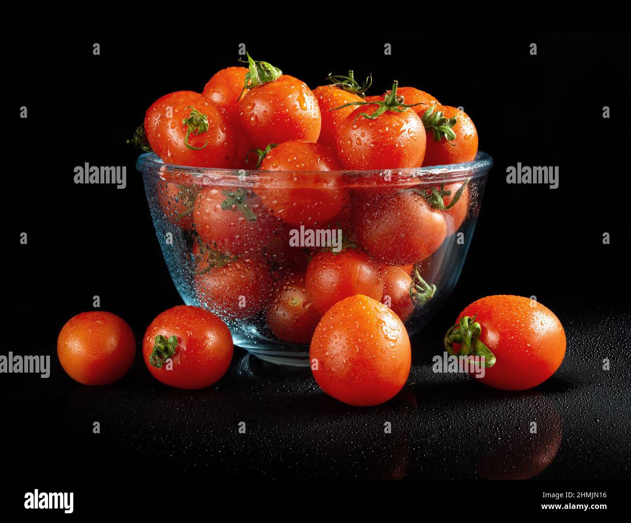 Cherry tomatoes on black reflective background Stock Photo - Alamy