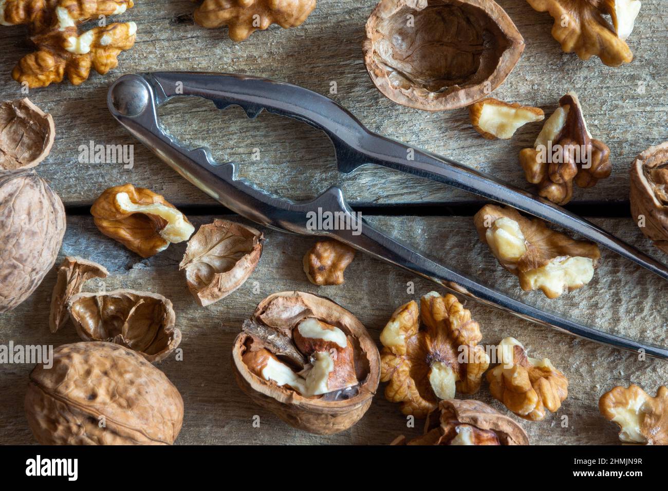 Walnuts and nutcracker on wooden background Stock Photo
