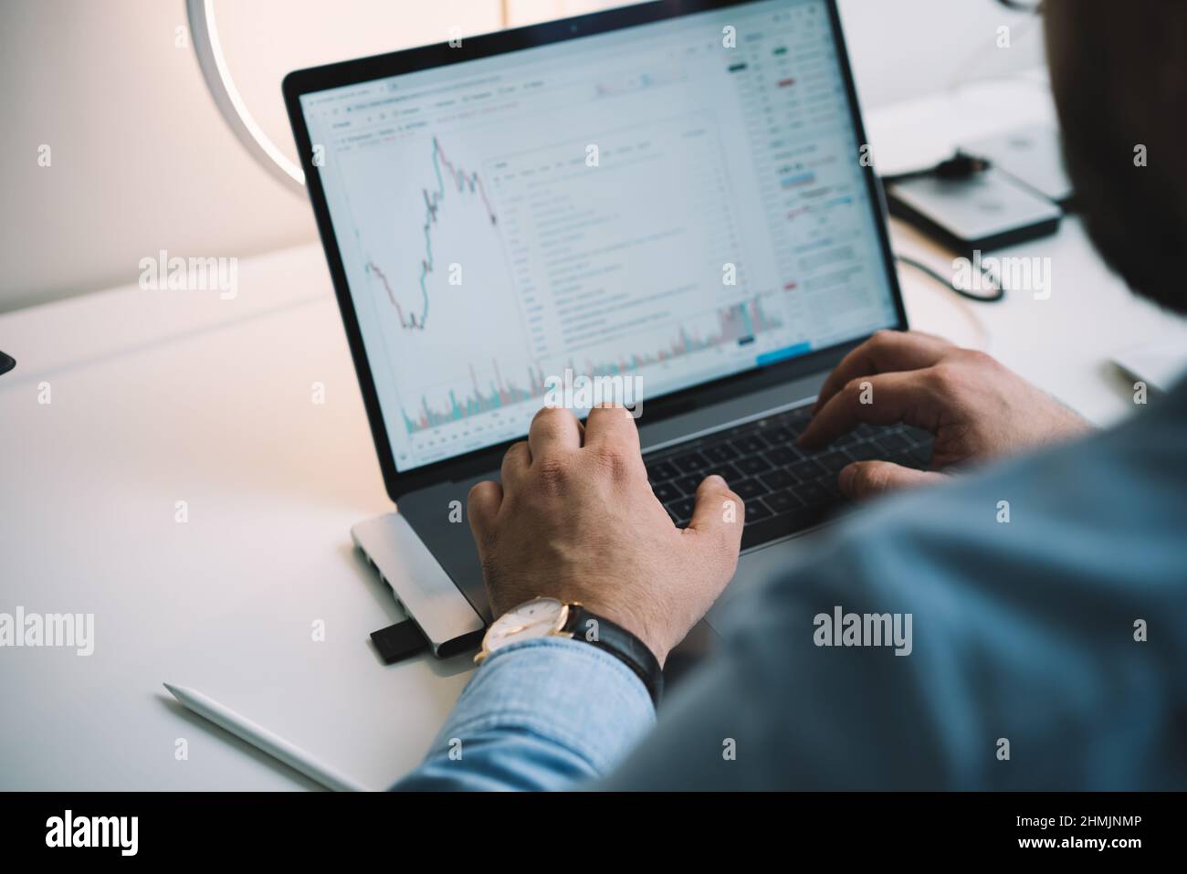 Anonymous male manager using netbook while analyzing financial charts in workplace Stock Photo
