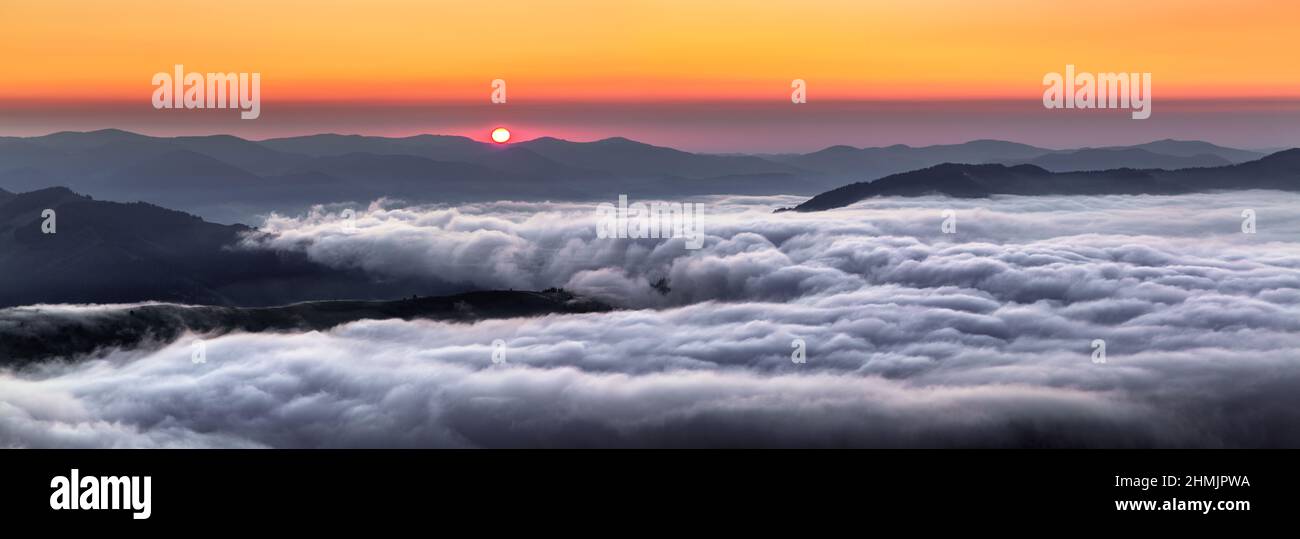 Panorama with amazing sunrise. Landscape with high mountains. Fields and meadow are covered with morning fog and dew. Touristic resort Carpathian nati Stock Photo