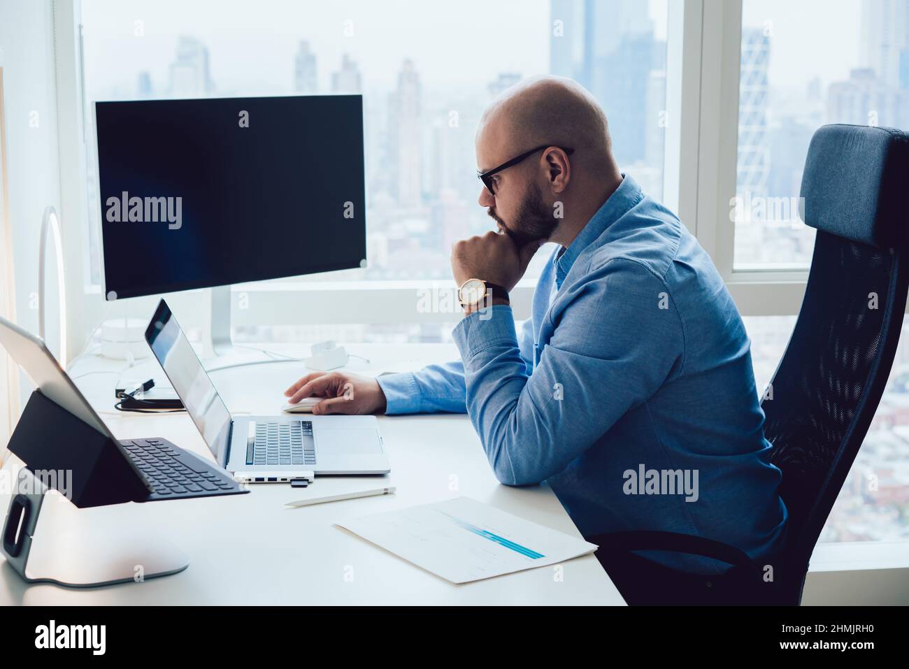 Pensive young smart businessman browsing netbook during work in office Stock Photo