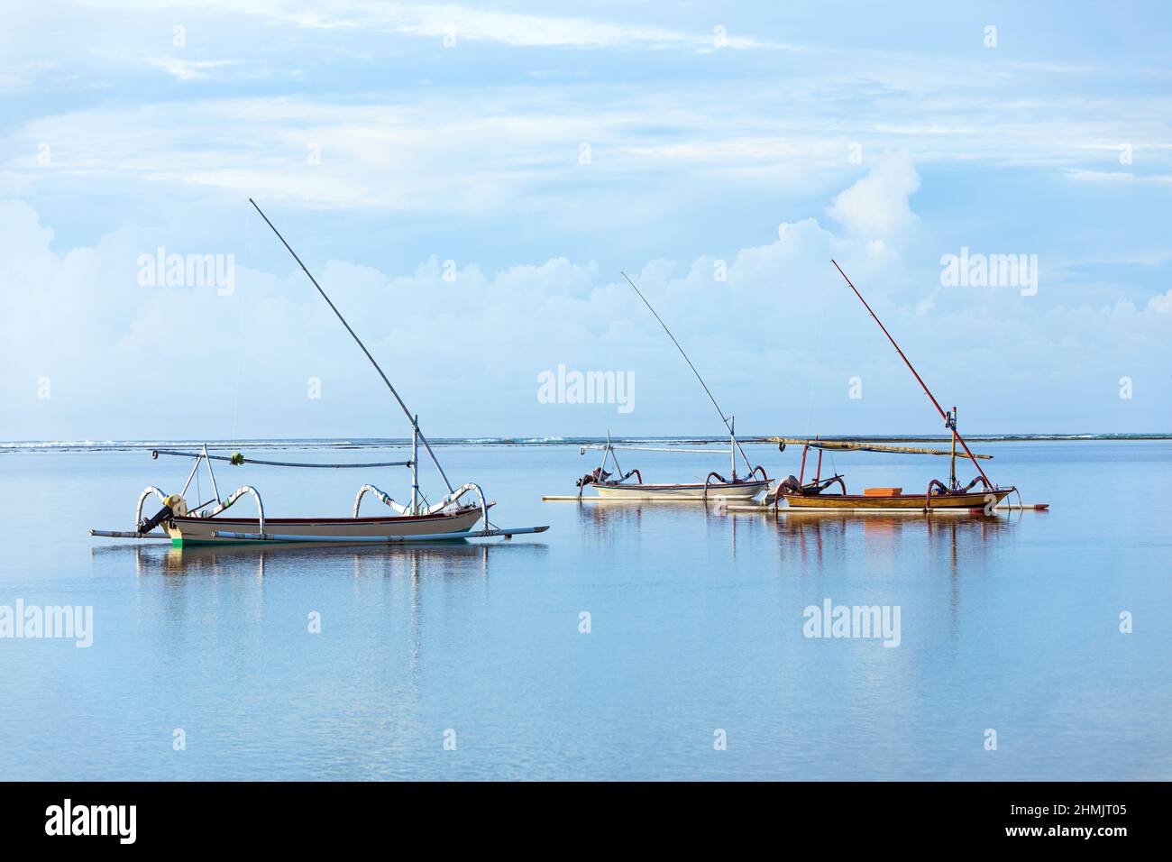 Fishing boats floating on the ocean. Wooden boat sailing in open waters. Sailing boat landscape. High waves with foam spread on the coast. Tropical la Stock Photo