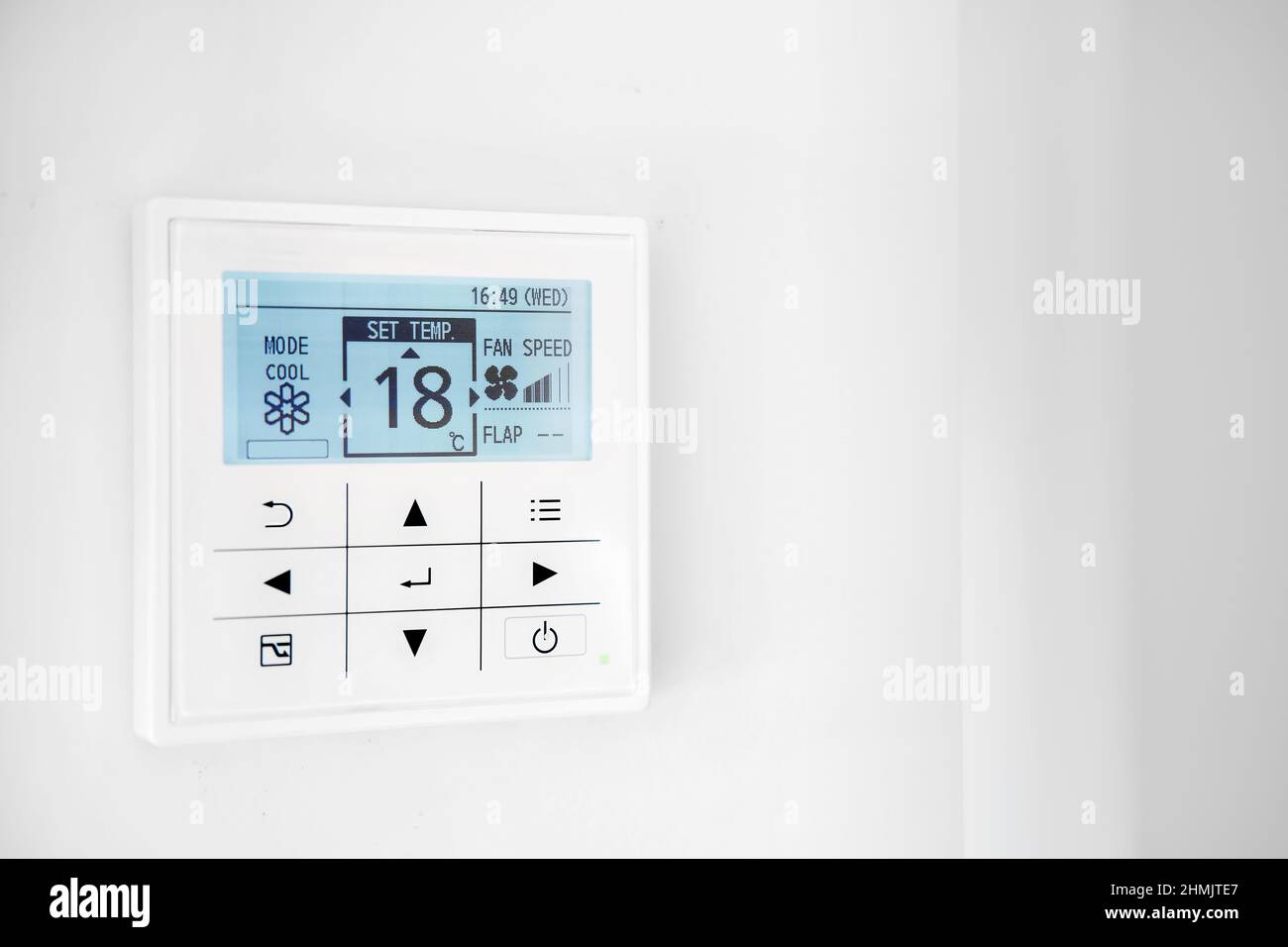 Mounted on wall, climate control show 18 degrees indoor, remote air-conditioner inside smart home close up view, no people. Modern tech, comfort livin Stock Photo