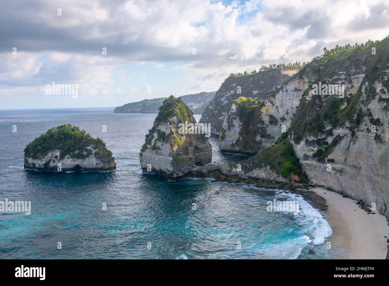 Scenery of sunny day with sand beach, turquoise ocean and mountains. View of Diamond beach, Nusa Penida, Bali island, Indonesia. Wallpaper background. Stock Photo