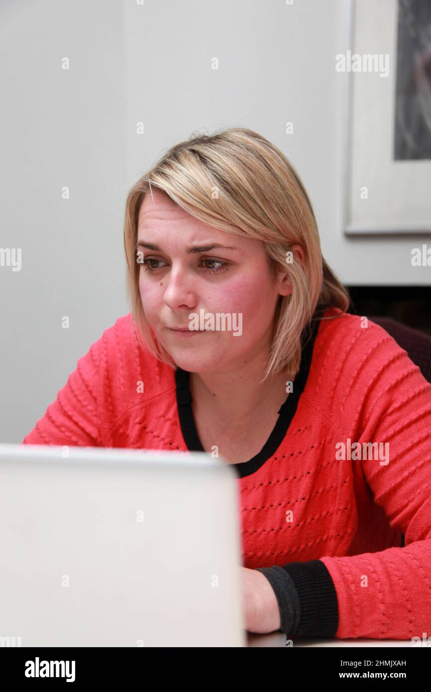 A young female working from home on her laptop. Stock Photo
