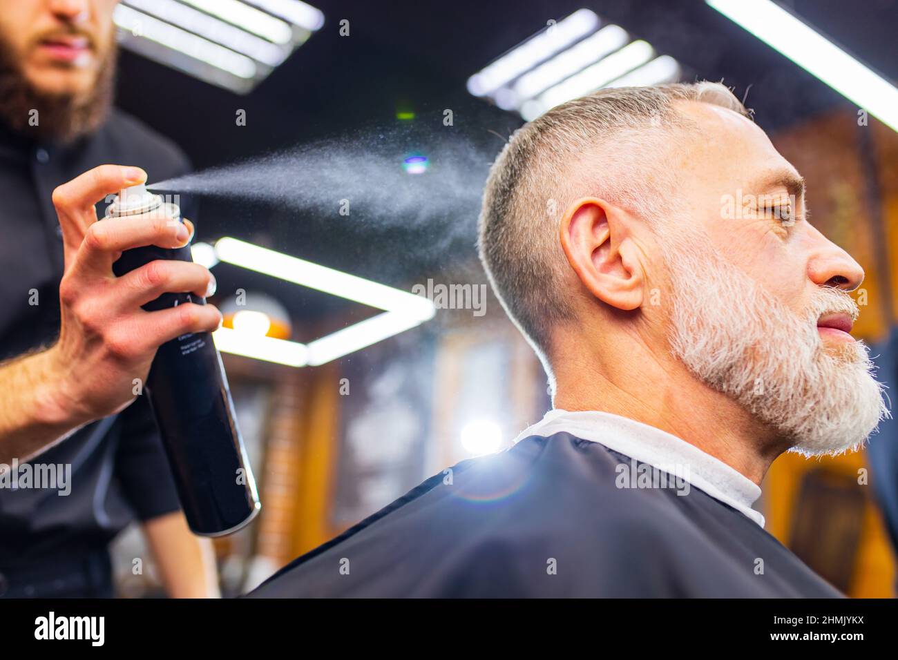 Senior handsome man visiting hairstylist in modern barber shop Stock ...