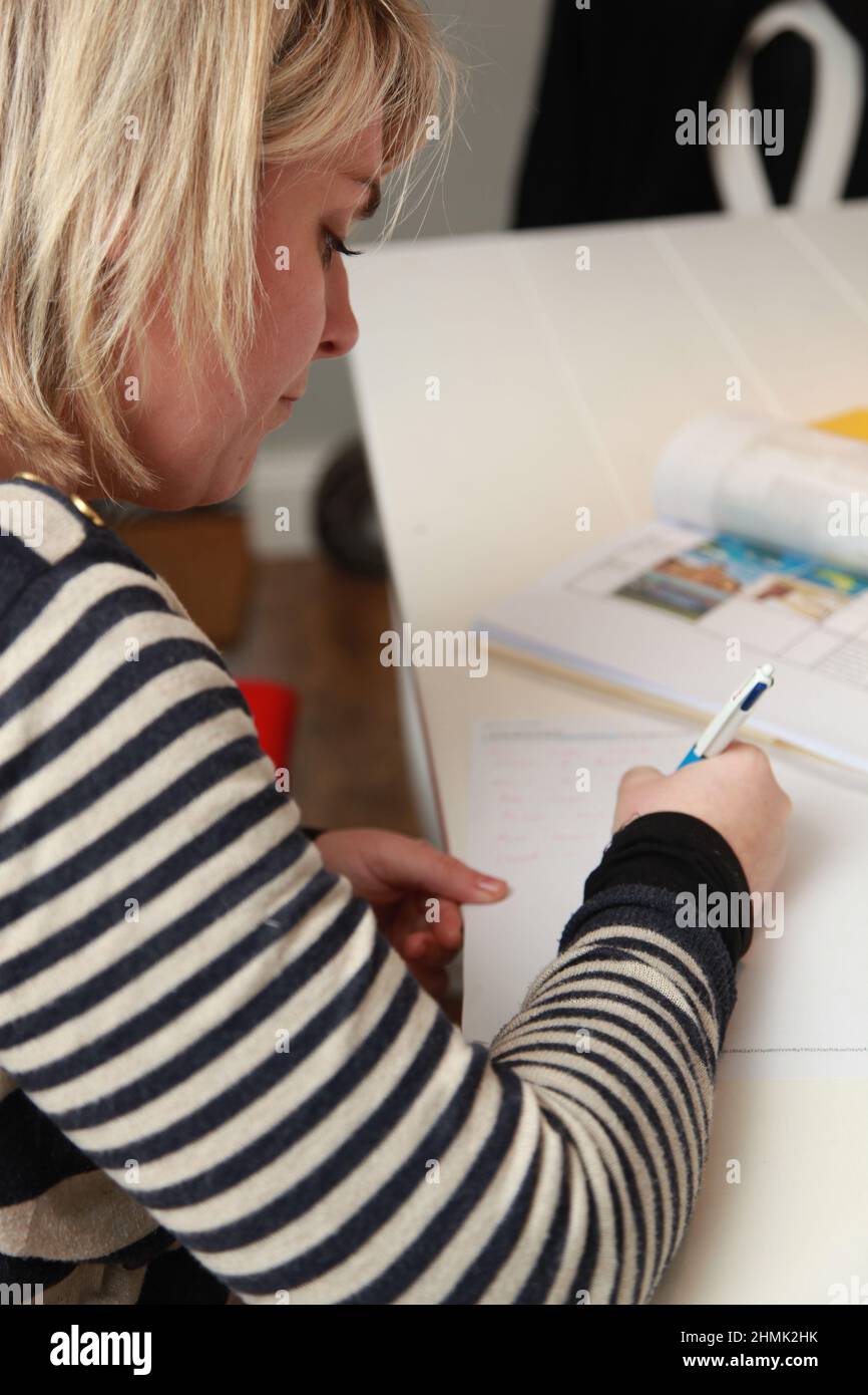 A young female at home writing and planning. UK Stock Photo