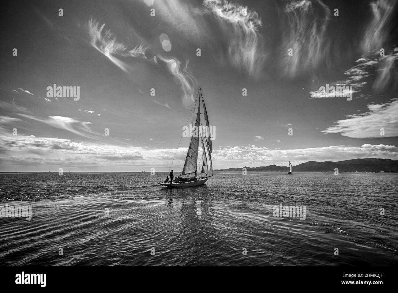mediterranean sea black white sky quiet sea sailing boat away Stock Photo