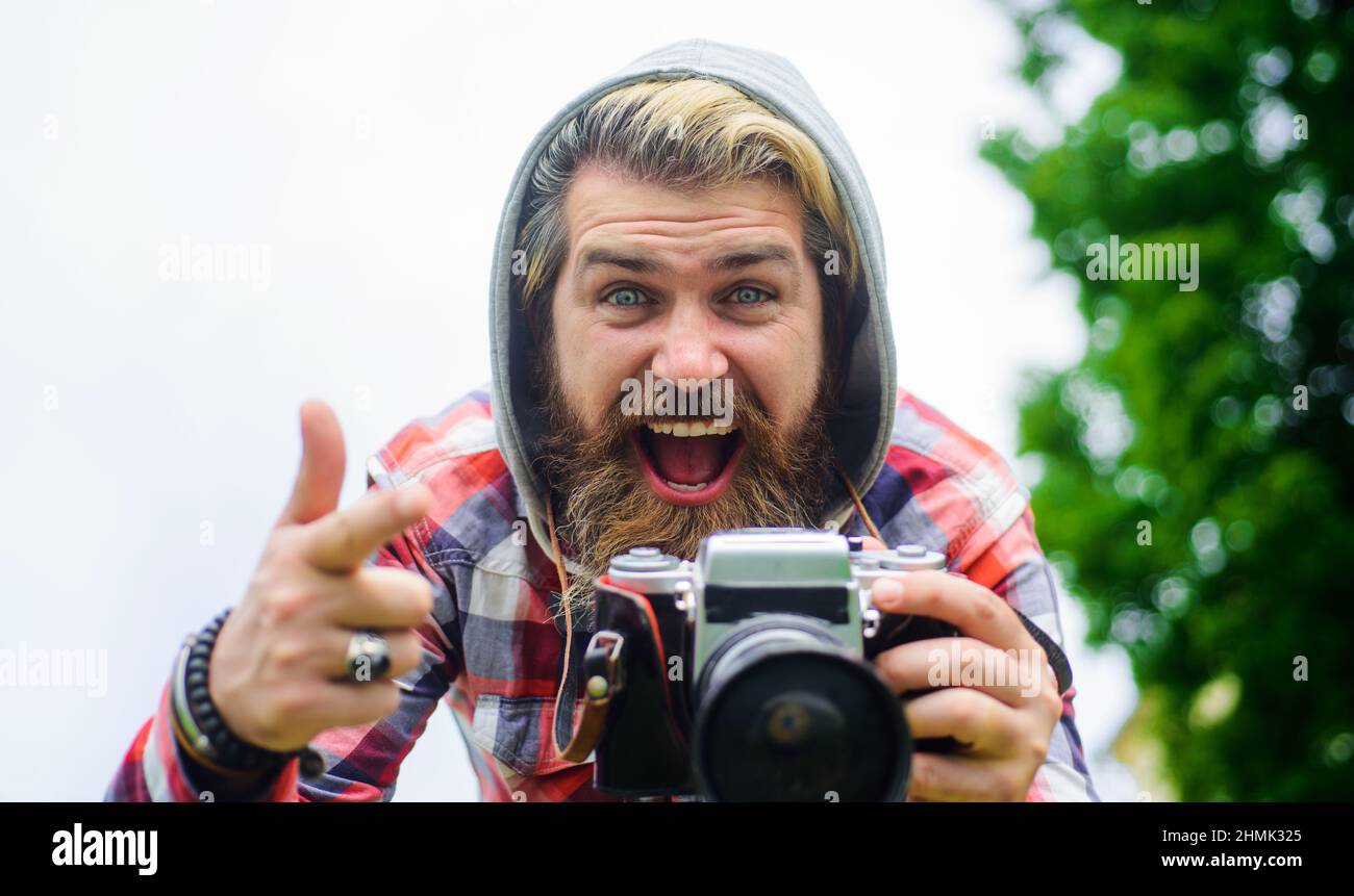 Happy bearded man taking photo. Tourist with photocamera in city. Travel and tourism. Photographer. Stock Photo