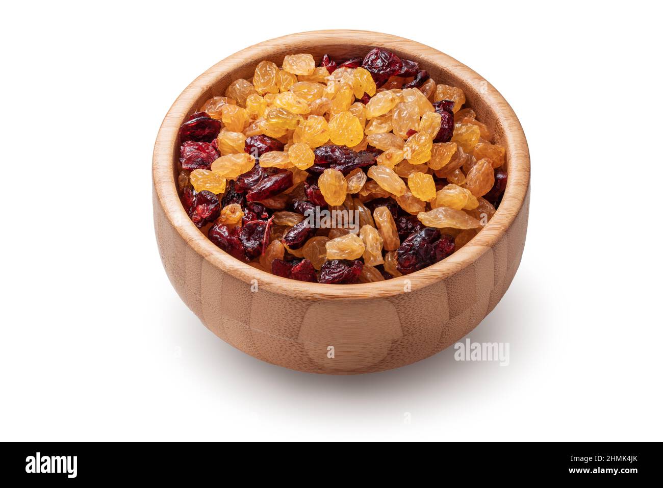 Organic dried raisins and cranberries in wooden bowl isolated on white