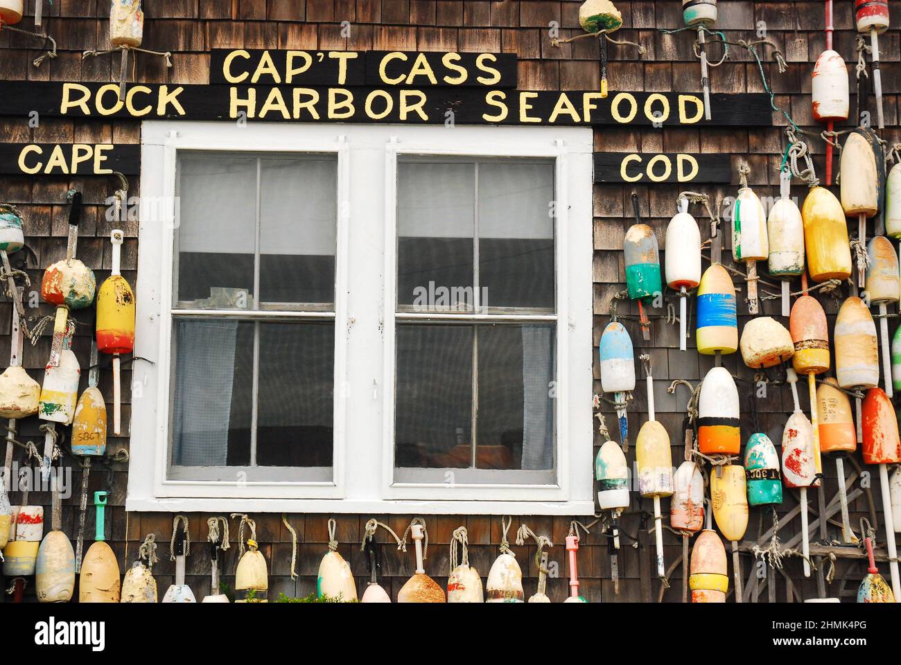 The exterior shingled wall of the  seafood restaurant Capt Cass on Cape Cod is decorated with lobster buoys from local fishermen Stock Photo