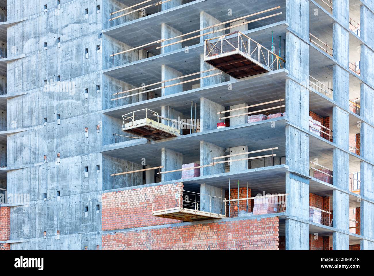 Brick walls and internal partitions are gradually erected on the concrete frame of the house