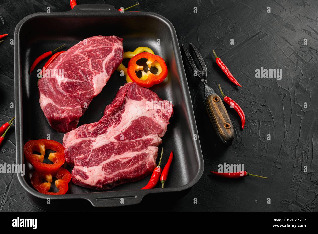 Raw chuck roll steaks premium beef with seasonings set, on black dark