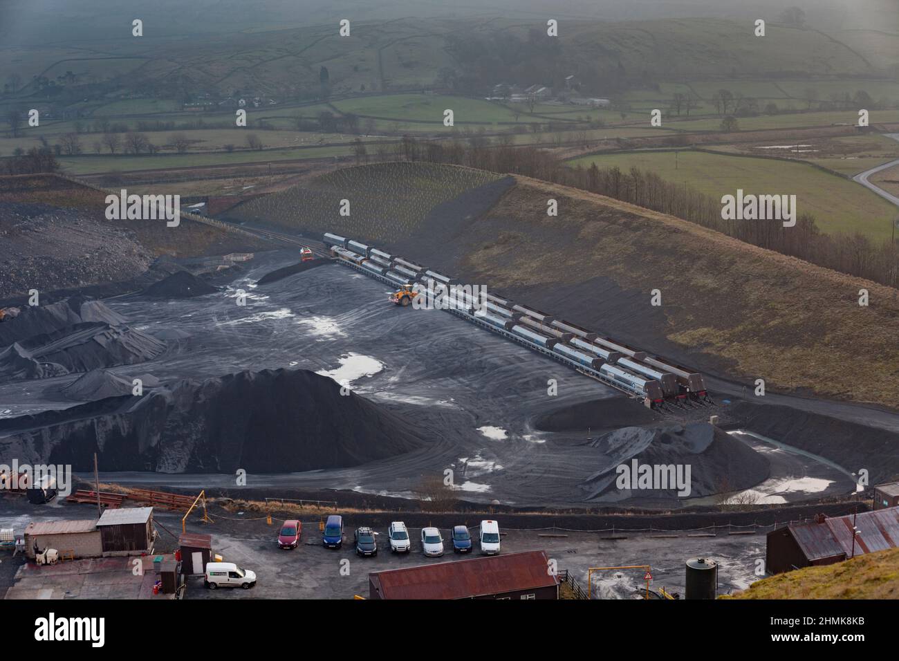 GB Railfreight class 66 locomotive at Arcow Quarry, Helwith Bridge, Yorkshire waiting while a train is loaded with stone using a loading shovel Stock Photo