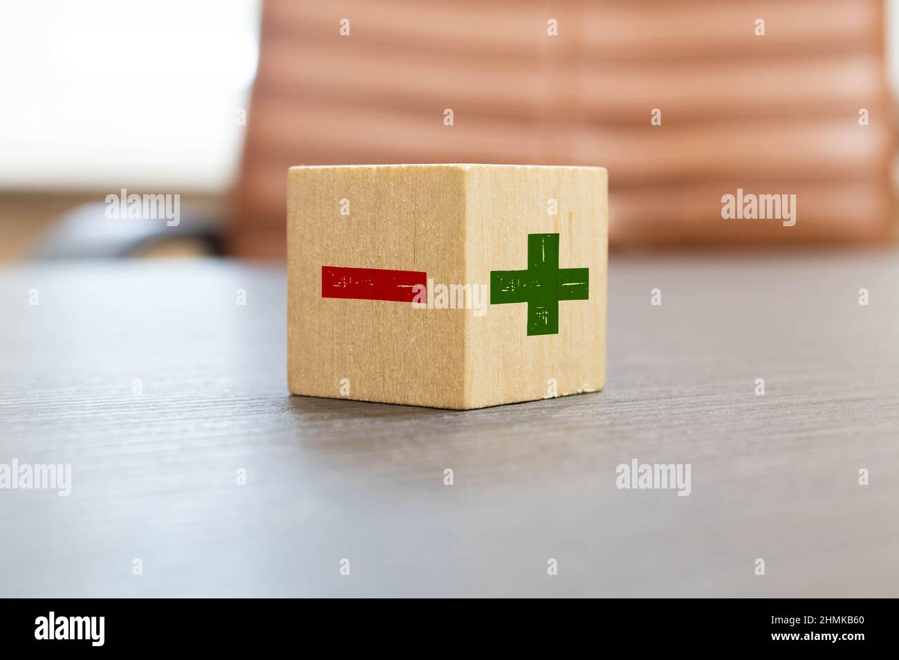 Flipping wooden cube block to change minus sign to plus sign on blue background. Positive thinking and mindset concept. Stock Photo