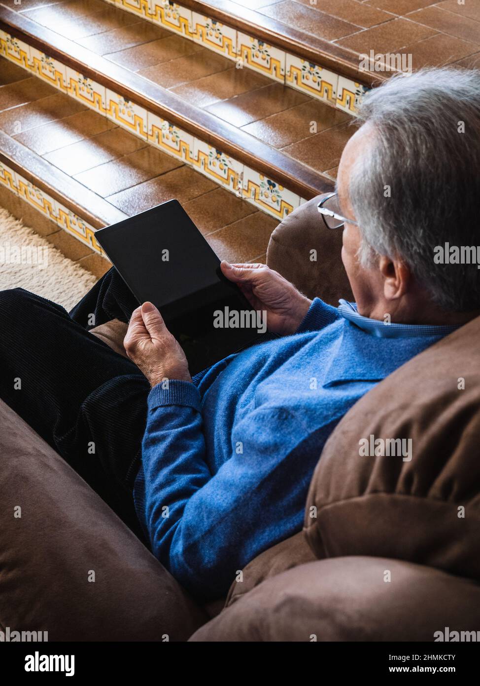 Old man looking a tablet in house Stock Photo