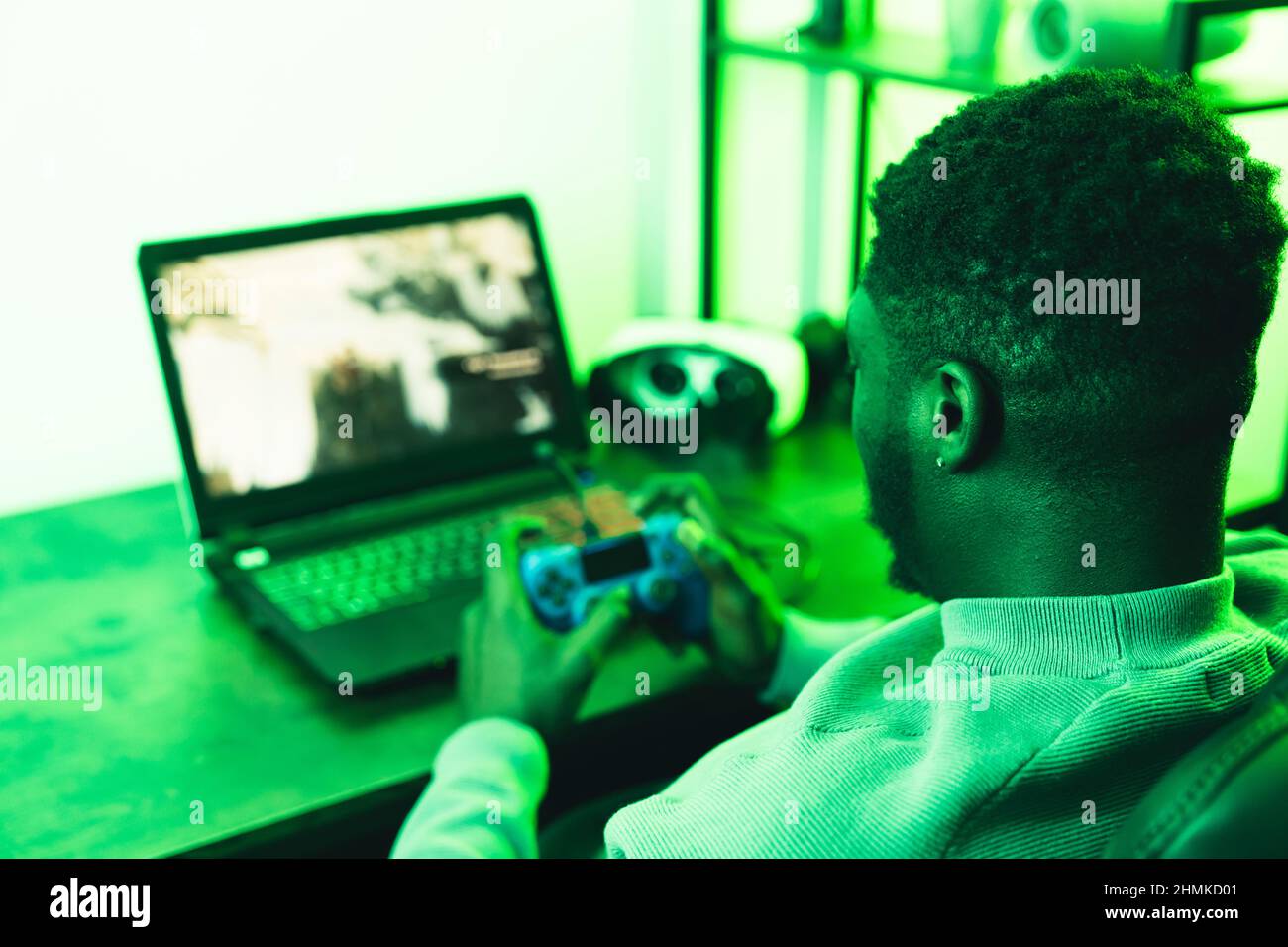 Black man playing laptop computer game pad - over shoulder shot. High quality photo Stock Photo
