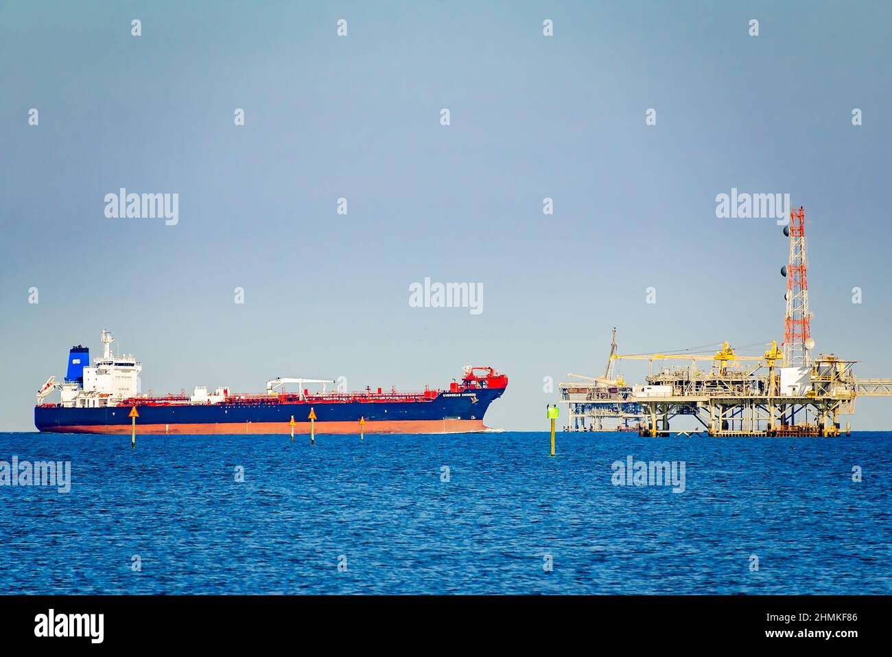 Overseas Chinook, a chemical tanker or oil tanker vessel, passes a natural gas platform, Feb. 9, 2010, in Dauphin Island, Alabama. Stock Photo
