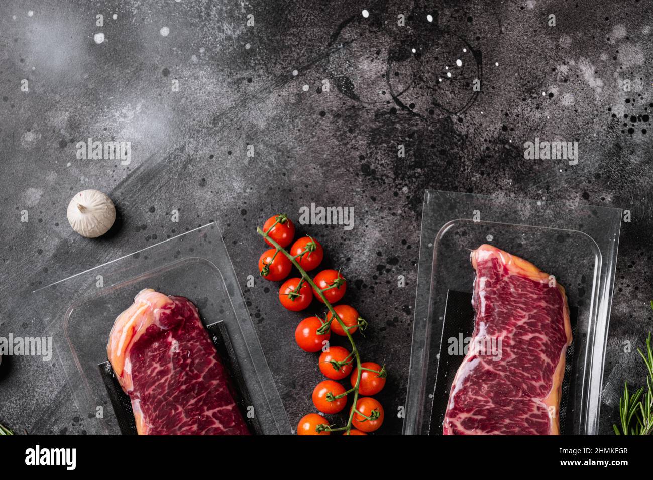 New York steak in vacuum pack set, on black dark stone table background ...